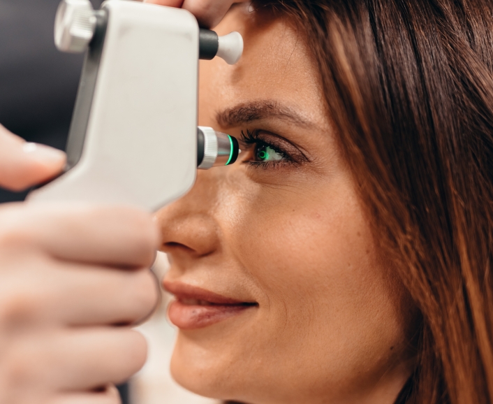 Ophthalmologist examining patient’s eye with modern equipment in clinic